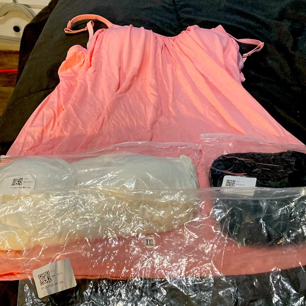 Set of tank tops.  Pink, white and black, never worn.  Each has a shelf bra.